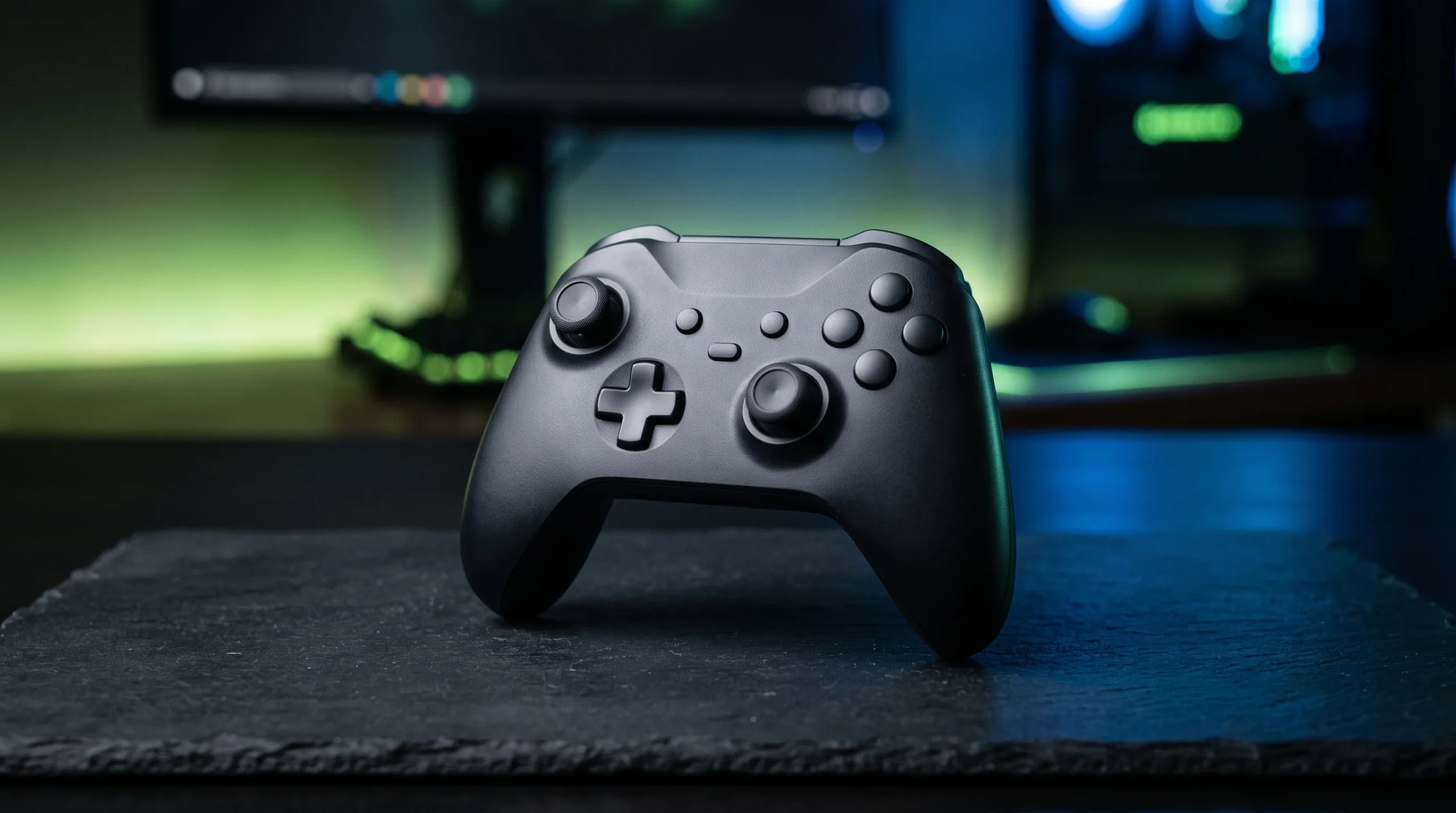 A close-up of a modern video game controller illuminated by ambient lights.