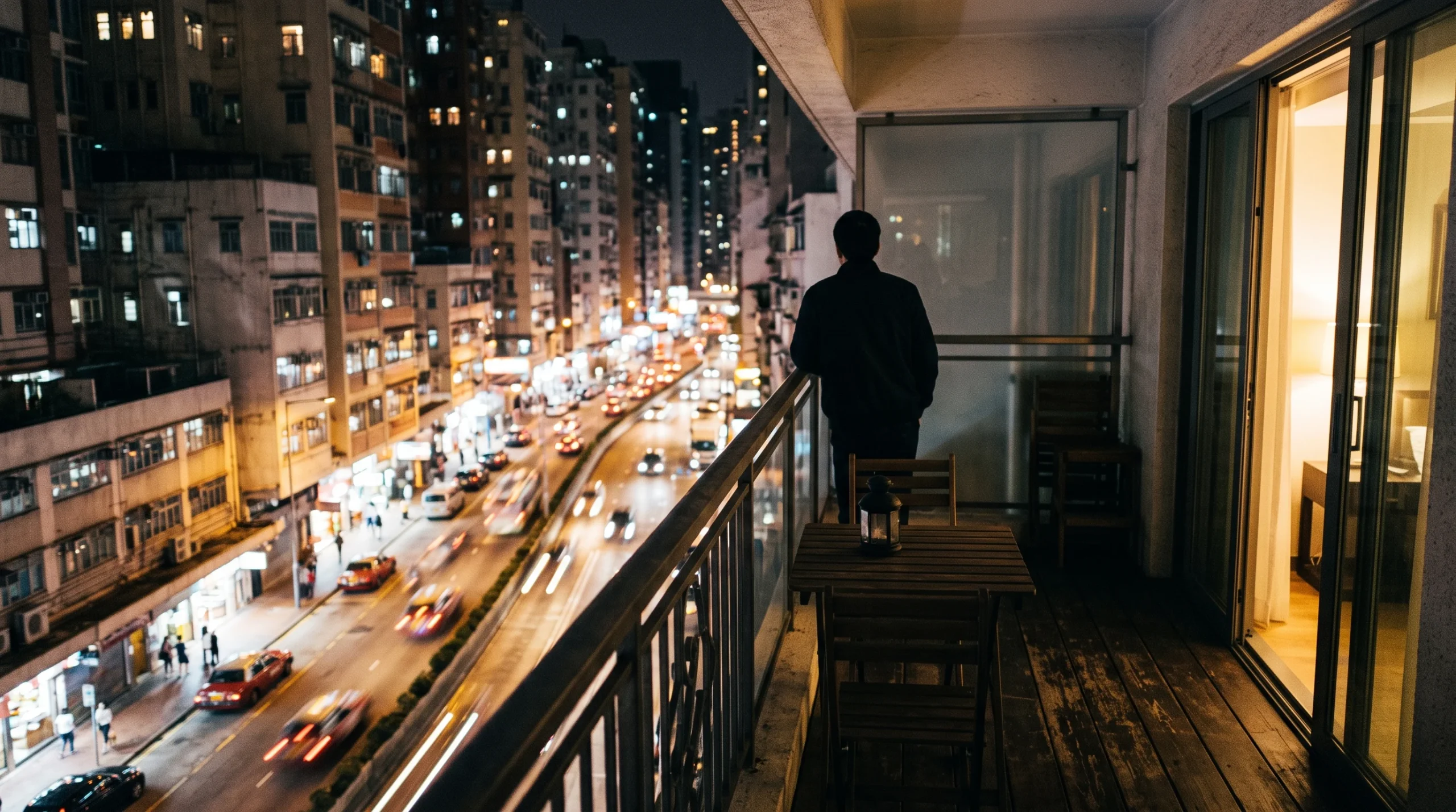 A balcony overlooking a city street in Lima at night.